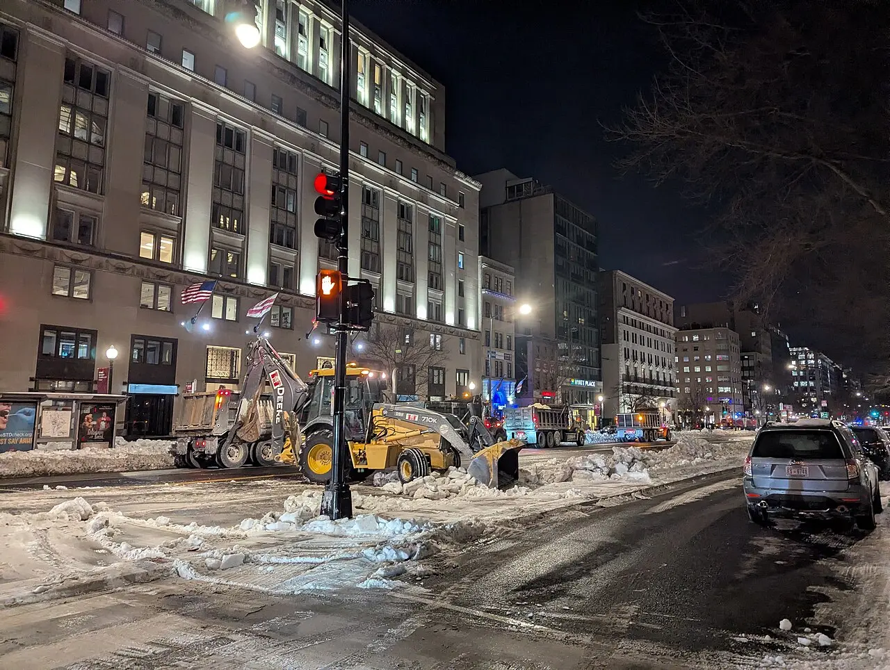 Vehicles clearing snow from a Washington street after a storm.