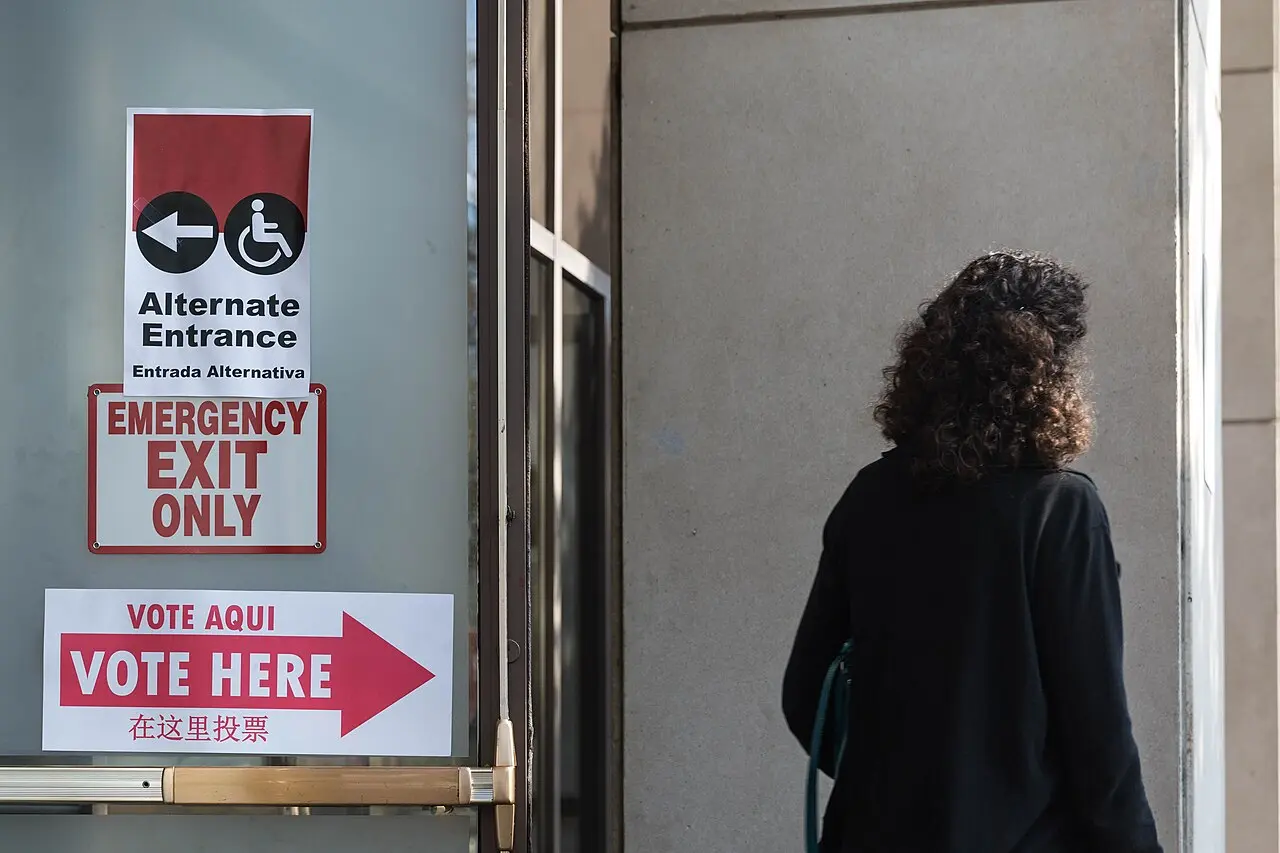 Bilingual signs reading Vote Aqui and Vote Here outside a polling place in Washington.